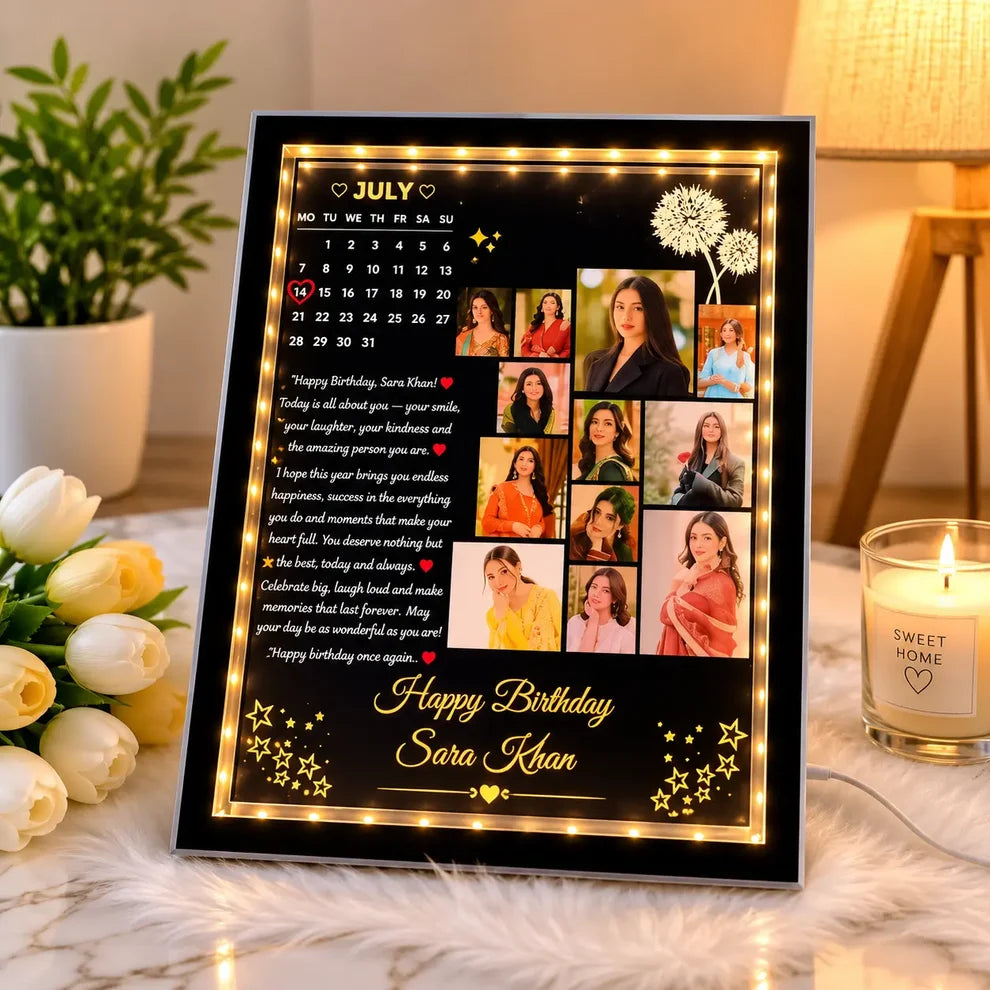 A personalized framed birthday photo board with built-in warm white LED lights, shown in a cozy home setting with a lit candle, flowers, and a lamp in the background.